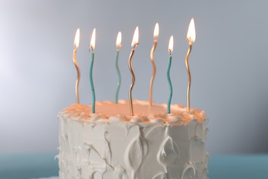 Photo of Tasty Birthday cake with burning candles on gray background, closeup