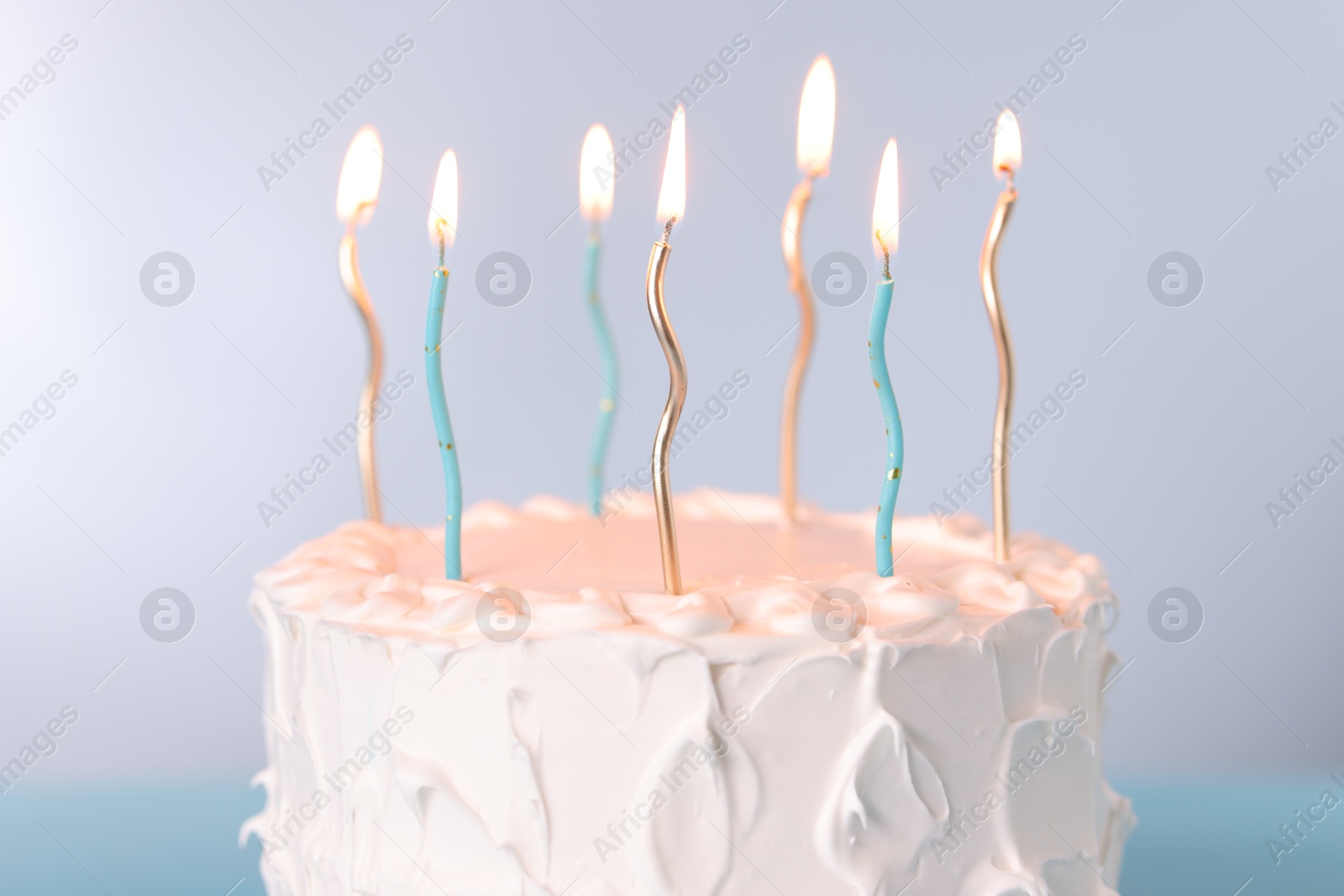 Photo of Tasty Birthday cake with burning candles on gray background, closeup