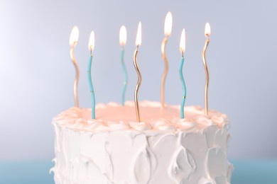 Tasty Birthday cake with burning candles on gray background, closeup