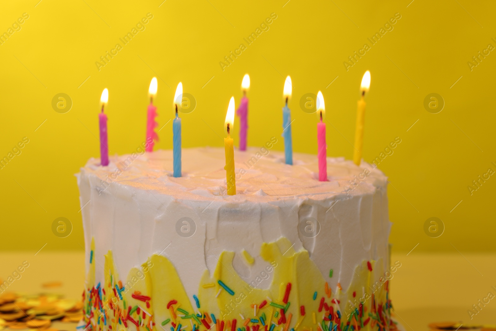 Photo of Tasty Birthday cake with burning candles on yellow background, closeup