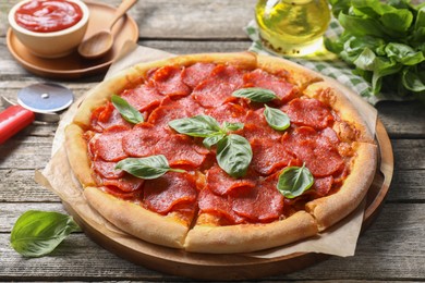 Photo of Tasty pepperoni pizza, ingredients and cutter on wooden table