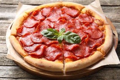 Photo of Tasty hot pepperoni pizza on wooden table, closeup