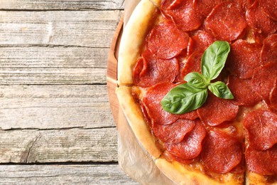 Photo of Tasty pepperoni pizza on wooden table, top view. Space for text