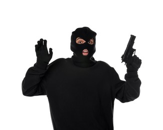 Emotional thief in balaclava with gun raising hands on white background