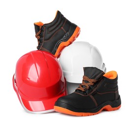 Photo of Pair of working boots and hard hats isolated on white
