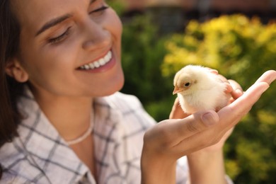 Woman with cute chick outdoors, selective focus