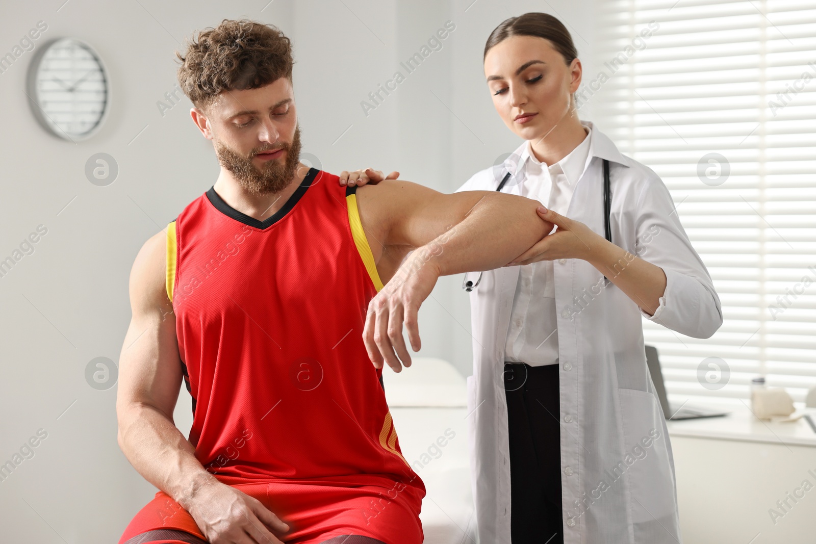 Photo of Sports injury. Doctor examining patient's hand in hospital