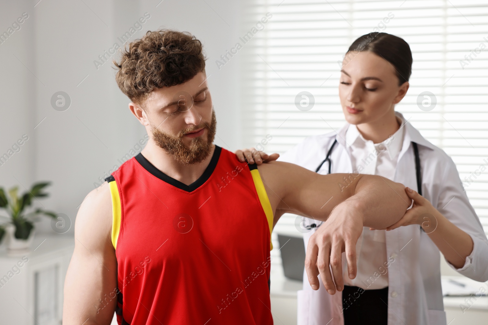 Photo of Sports injury. Doctor examining patient's hand in hospital