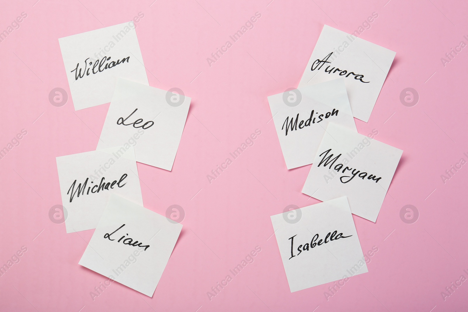 Photo of Paper stickers with different names on pink background, flat lay. Choosing baby's name