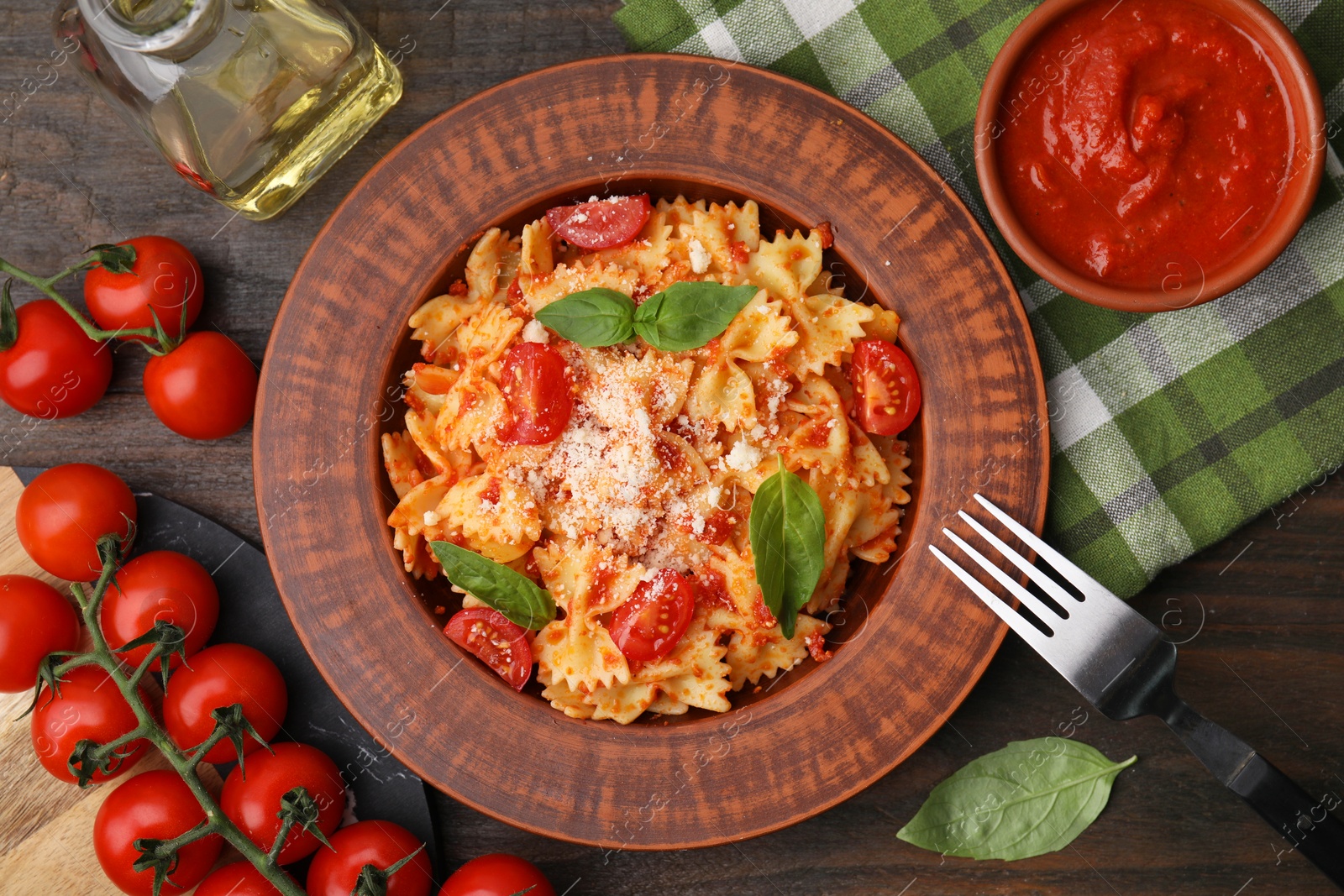 Photo of Tasty pasta with tomato sauce, cheese and basil served on wooden table, flat lay