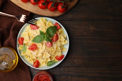 Photo of Tasty pasta with tomato, cheese and basil served on wooden table, flat lay. Space for text