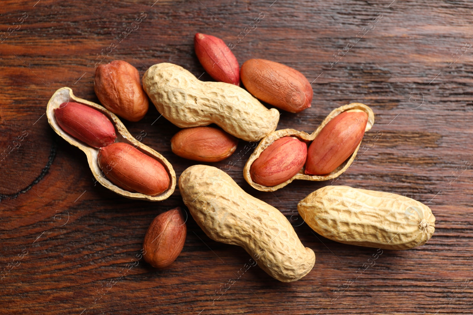 Photo of Fresh unpeeled peanuts on wooden table, top view