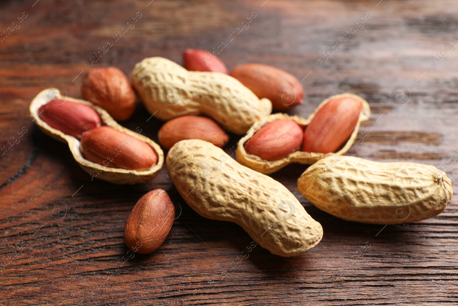 Photo of Fresh unpeeled peanuts on wooden table, closeup