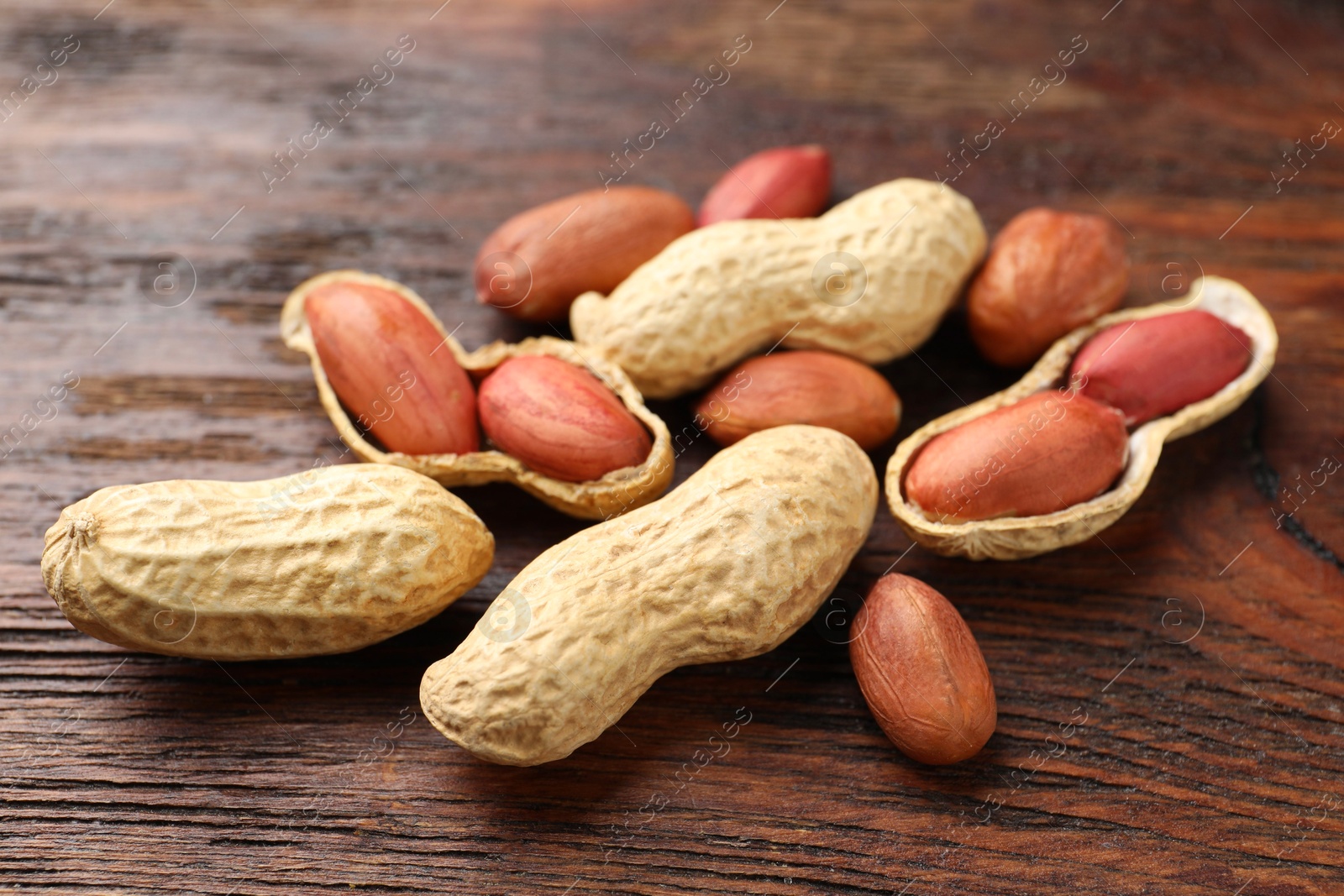 Photo of Fresh unpeeled peanuts on wooden table, closeup