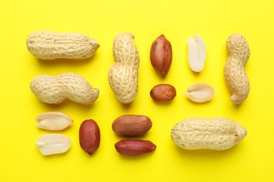 Fresh peanuts on yellow background, flat lay