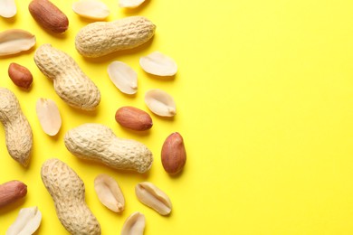 Fresh peanuts on yellow background, flat lay. Space for text