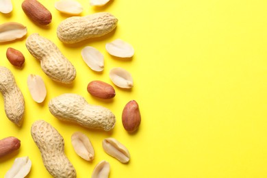 Photo of Fresh peanuts on yellow background, flat lay. Space for text