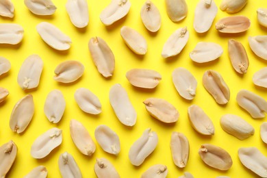 Photo of Fresh peanuts on yellow background, top view