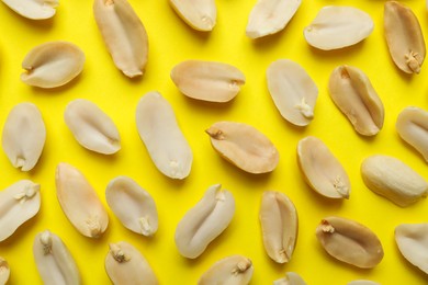 Photo of Fresh peanuts on yellow background, top view