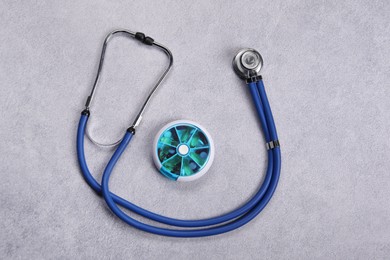 Photo of Stethoscope and pills on gray background, flat lay. Medical treatment