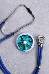 Photo of Stethoscope and pills on gray background, flat lay. Medical treatment