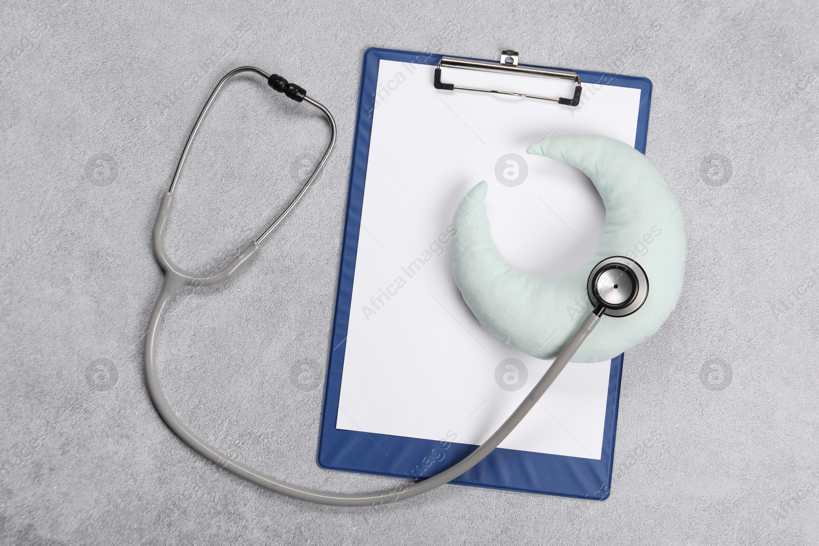 Photo of Clipboard, stethoscope and pillow on gray textured background, top view. Children's hospital