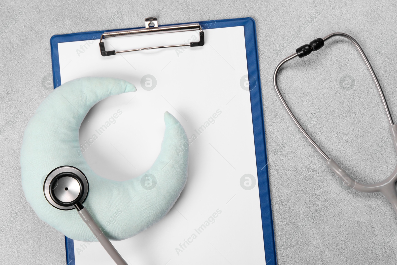 Photo of Clipboard, stethoscope and pillow on gray textured background, top view. Children's hospital