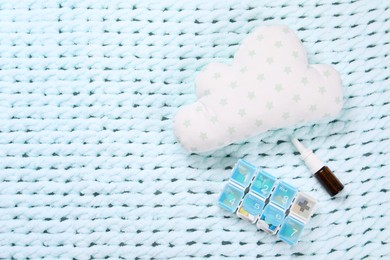 Photo of Pillow, pills and nasal spray on light blue blanket, flat lay. Space for text
