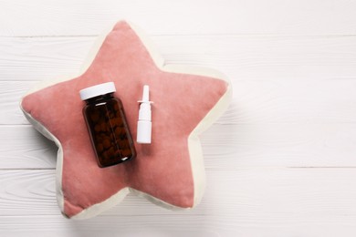 Photo of Pillow, pills and nasal spray on white wooden background, top view. Space for text