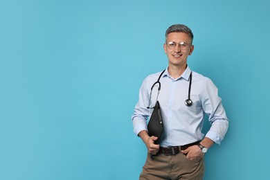 Doctor with stethoscope and clipboard on light blue background, space for text