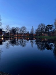 Photo of Scenic view of river and buildings on shore in evening