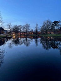 Photo of Scenic view of river and buildings on shore in evening