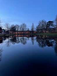 Scenic view of river and buildings on shore in evening