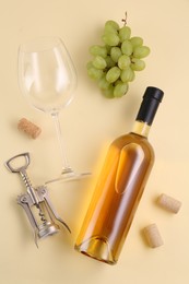 Flat lay composition with wing corkscrew and wine on beige background