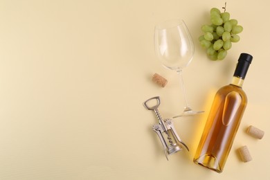 Flat lay composition with wing corkscrew and wine on beige background, space for text