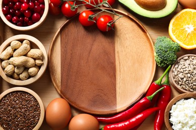 Photo of Tray with many different healthy food and plate on wooden table, top view. Space for text