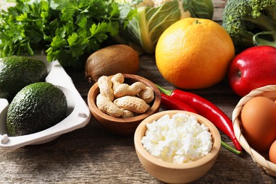 Healthy meal. Different vegetables and raw eggs on wooden table, closeup