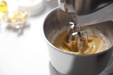 Making dough in bowl of stand mixer on white table, closeup. Space for text