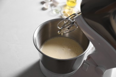 Photo of Making dough in bowl of stand mixer on white table. Space for text