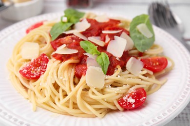 Photo of Tasty pasta with tomato sauce, cheese and basil on white table, closeup