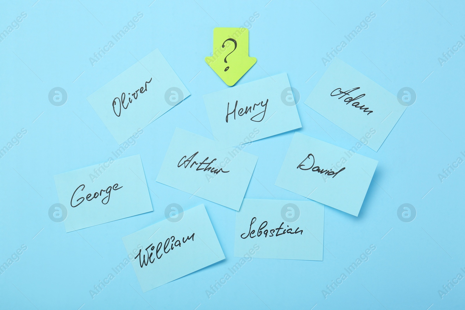 Photo of Choosing baby name. Paper stickers with different names and question mark on light blue background, flat lay