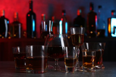 Different liqueurs in glasses on table in bar