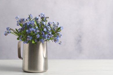 Beautiful forget-me-not flowers on white table, closeup. Space for text