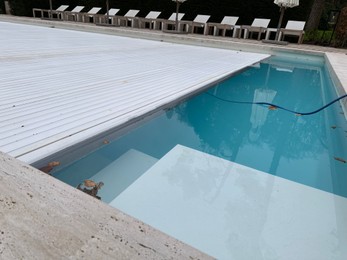 Outdoor swimming pool with cover and fallen leaves