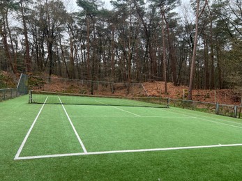 Tennis court with artificial grass and net outdoors