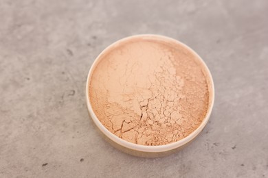 Photo of Face powder on grey textured table, closeup