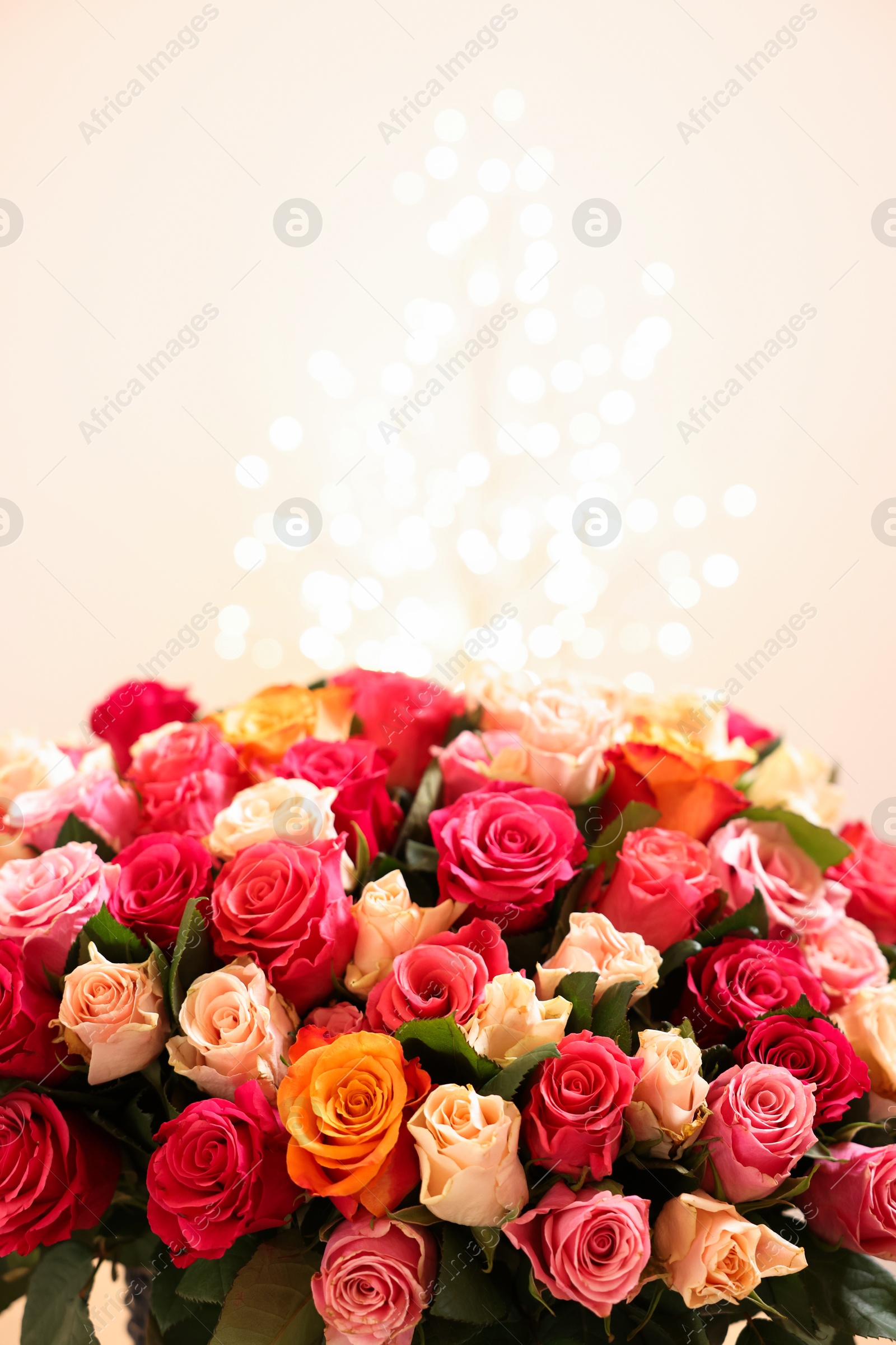 Photo of Beautiful bouquet of colorful roses on beige background