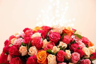 Photo of Beautiful bouquet of colorful roses on beige background