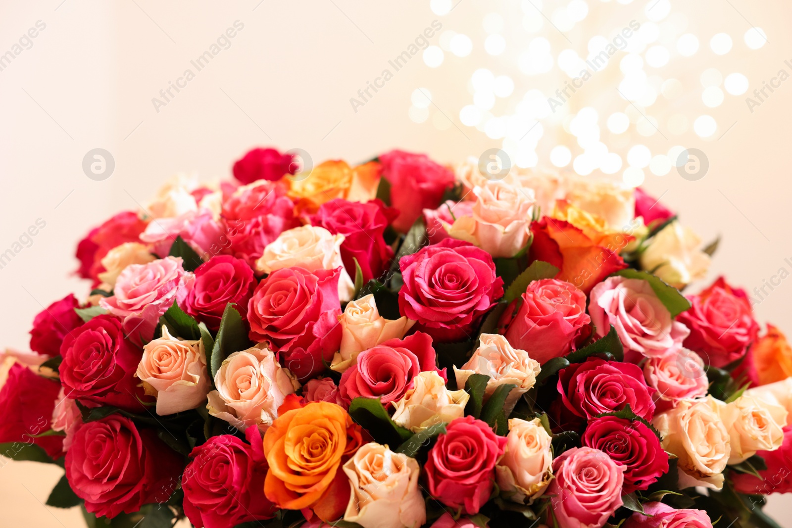 Photo of Beautiful bouquet of colorful roses on beige background