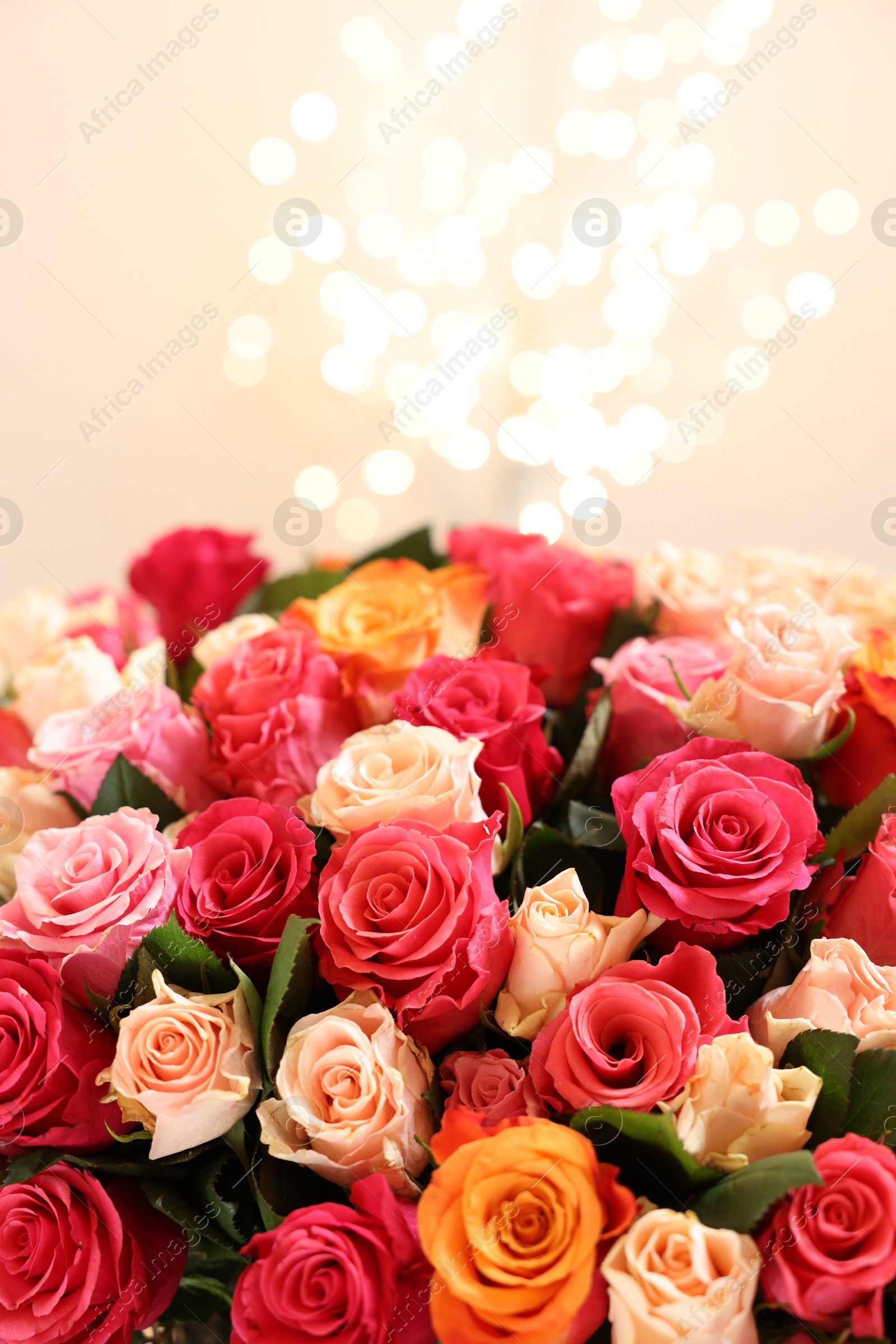 Photo of Beautiful bouquet of colorful roses on beige background